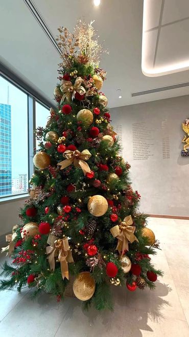Designer Christmas tree in law firm office featuring XL velvet baubles and berries with red & gold.
