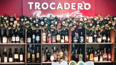 Modern pink and orange with gold baubles and roses Christmas Garland above bar at Auckland hotel.