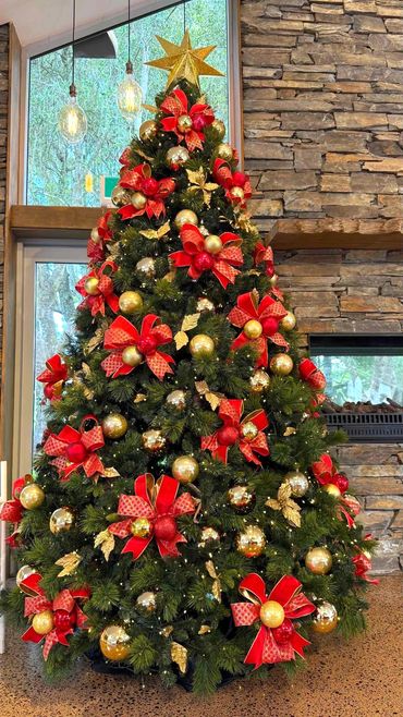 Handmade bauble bow Christmas tree featuring bright red wire edged ribbon, gold leaves + gib star.