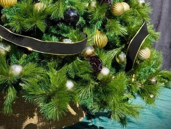 Closeup of black and gold decorations on Christmas tree.