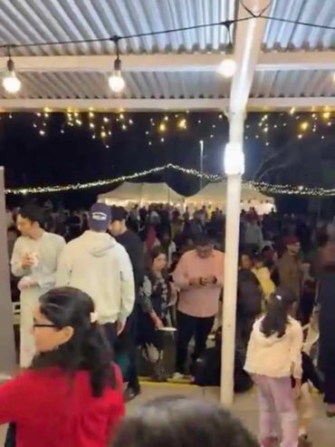 Festoons and warm white icicle lights at community event outdoors.