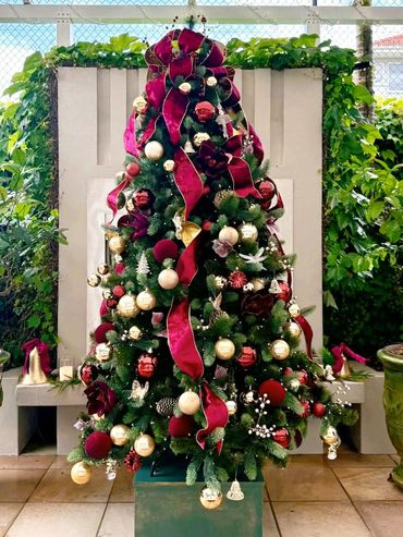 Purple/Burgundy velvet cascading ribbon with luxury ornaments & floral details on raised Xmas tree.