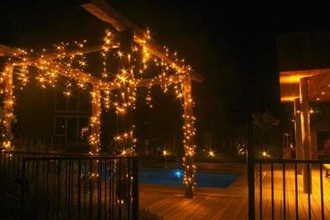 Warm white commercial fairy lights on gazebo at pool party.