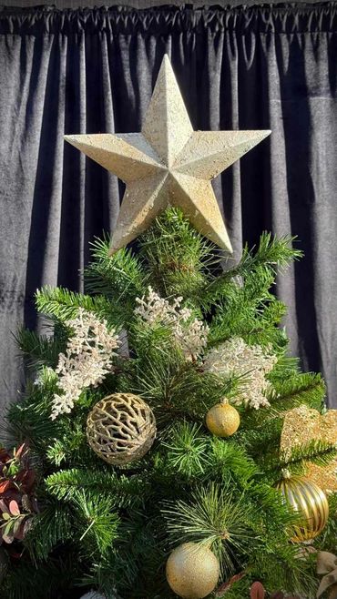 hand-painted Christmas tree star topper with gold and green decorations and touch of white foliage.
