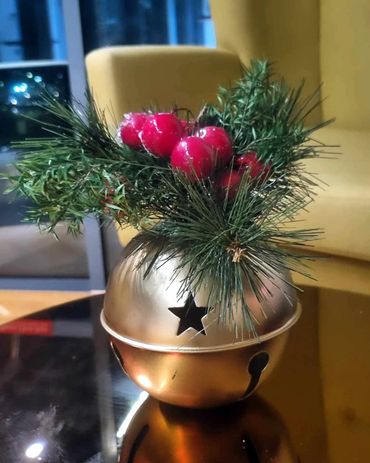 Giant gold bell with berries and pine for Christmas function.