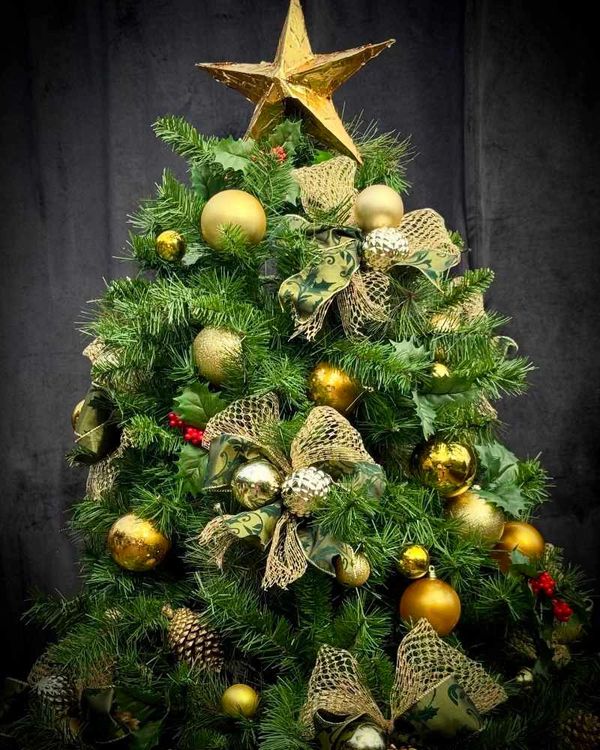 Closeup of Christmas tree topper featuring hand-made gold star and our fancy bows and baubles.