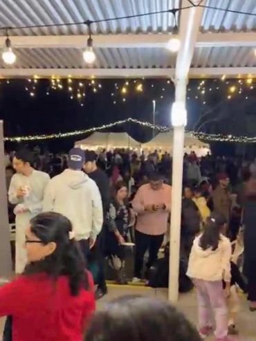 Festoons and warm white icicle lights at community event outdoors.