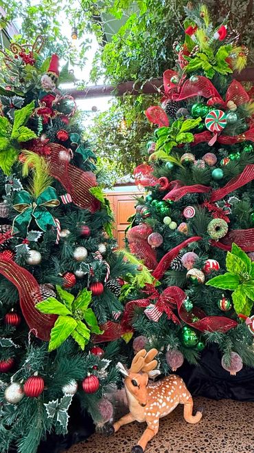 Closeup of green candy and elf themed Christmas tree cluster featuring sugar plums, & flowers.