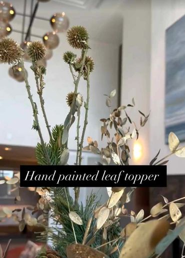 Fully deCloseup of preserved leaves and seed pods painted gold for Christmas tree topper.