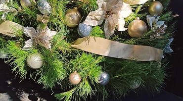 Closeup of real Christmas tree featuring Champaign satin ribbon + matching decorations + silver.