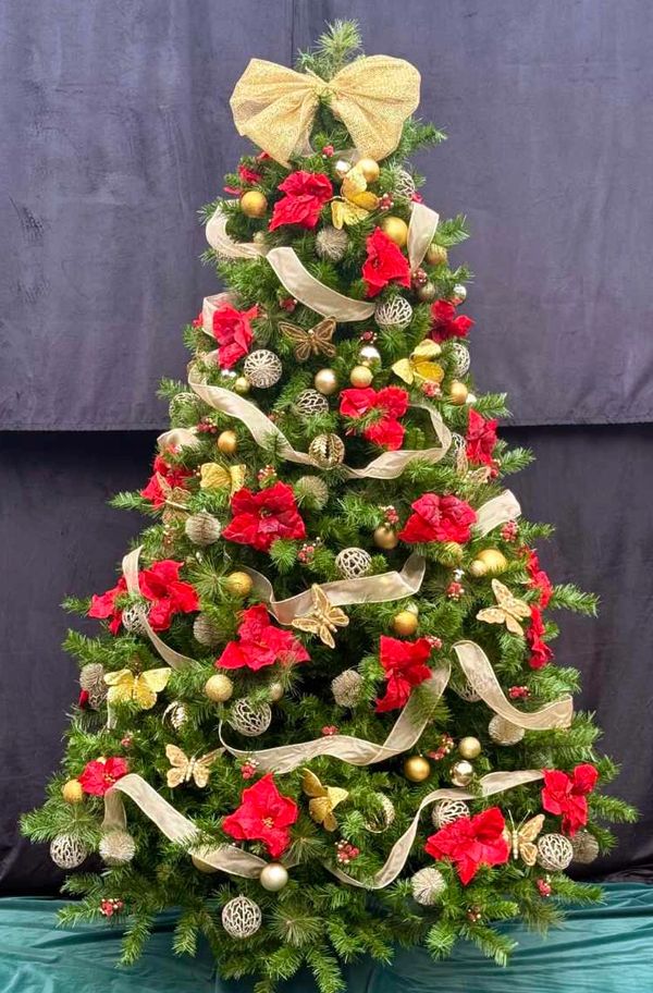 Luxury gold ribbon and butterfly Christmas tree with big fancy bow topper and red flowers.
