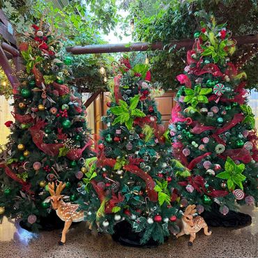 Vibrant green candy and elf themed Christmas tree cluster featuring sugar plums, & flowers.