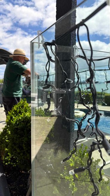 David and Ben installing commercial-grade icicle lights around swimming pool at private residence.