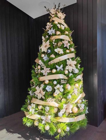 Real pine Christmas tree in home featuring Champaign satin ribbon + matching decorations + silver.