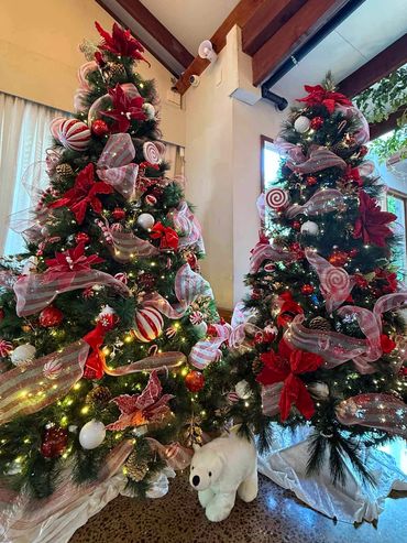 Fun candy cane themed Christmas tree cluster with white velvet and polar bear at base for party.