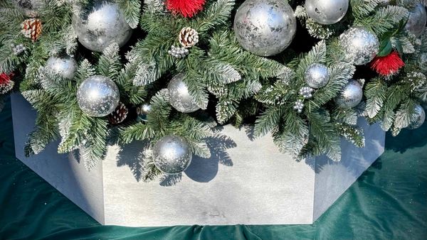 Closeup of silver wooden hexagon Christmas tree base on our 9 ft luxury Christmas tree.