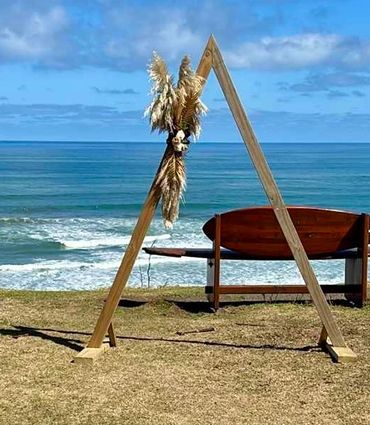 wooden boho style wedding arch for beach wedding with dried flowers.