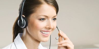 Smiling customer service representative wearing headset at work.