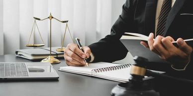 Lawyer working at desk with legal scales, gavel, and documents.