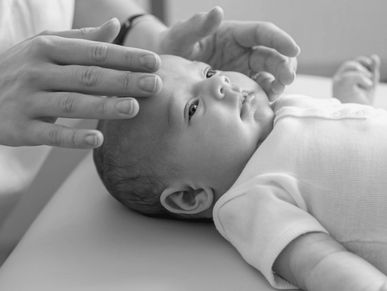 Infant receiving gentle Craniosacral Fascial Therapy (CFT), a technique used to relieve tension