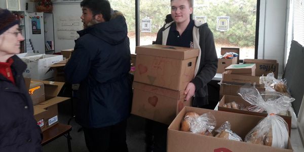 Individuals carrying boxes of food