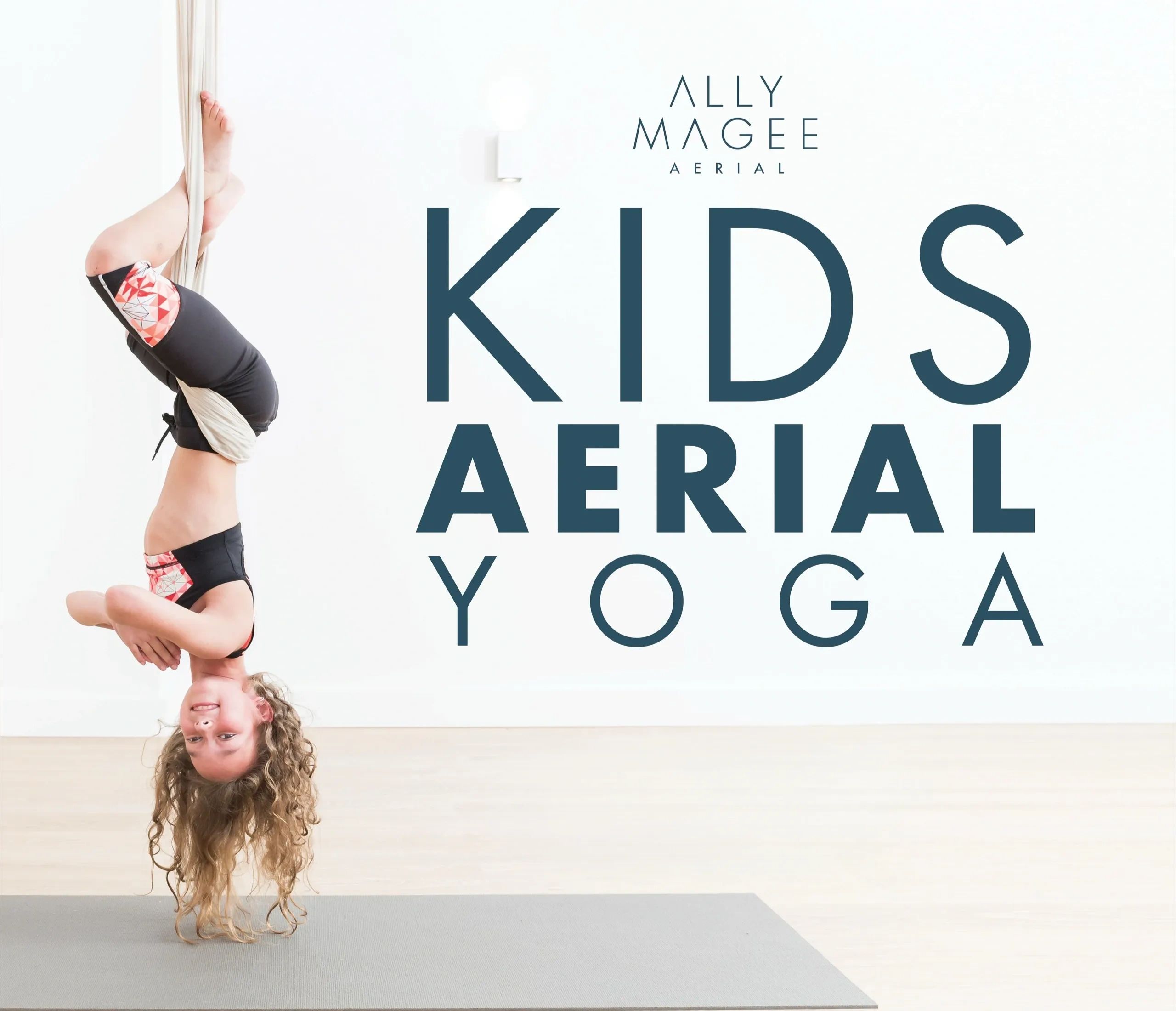 A child practicing aerial yoga upside down using fabric hammock.