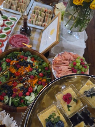 A colorful buffet spread with salads, sandwiches, and desserts.