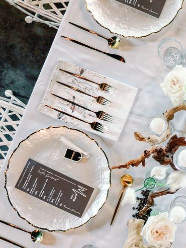 Elegant table setup with floral centerpiece and gold-accented dishware.