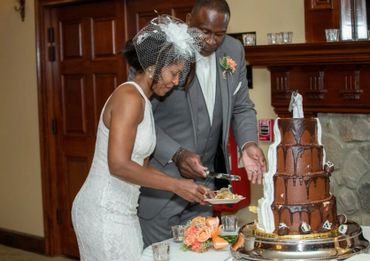 Bride and groom cutting their chocolate wedding cake together.