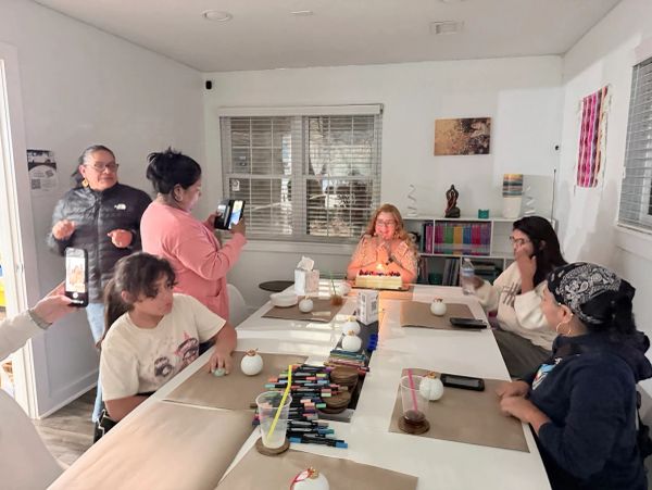 A group celebrating a birthday with a cake in a cozy room.