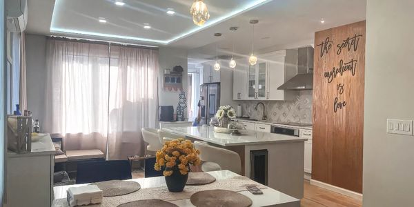 Bright, modern kitchen and dining area with elegant lighting and cozy decor.