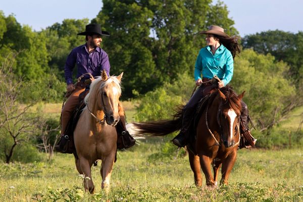 Elliot and Caitie Holtzman horsemen riding through field