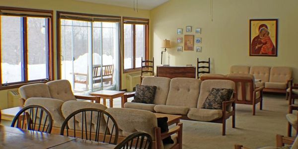 Great room at Emmaus House - guesthouse at New Skete monastery.  Snow in windows.  Couches and chair