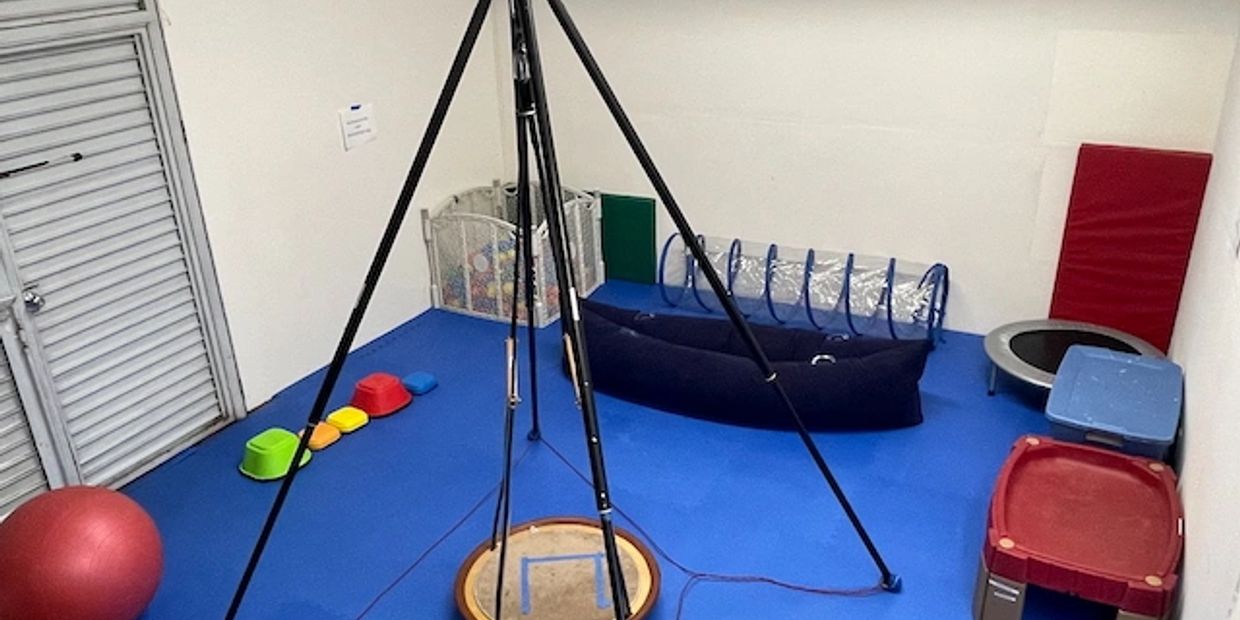 Therapy room with sensory and play equipment.