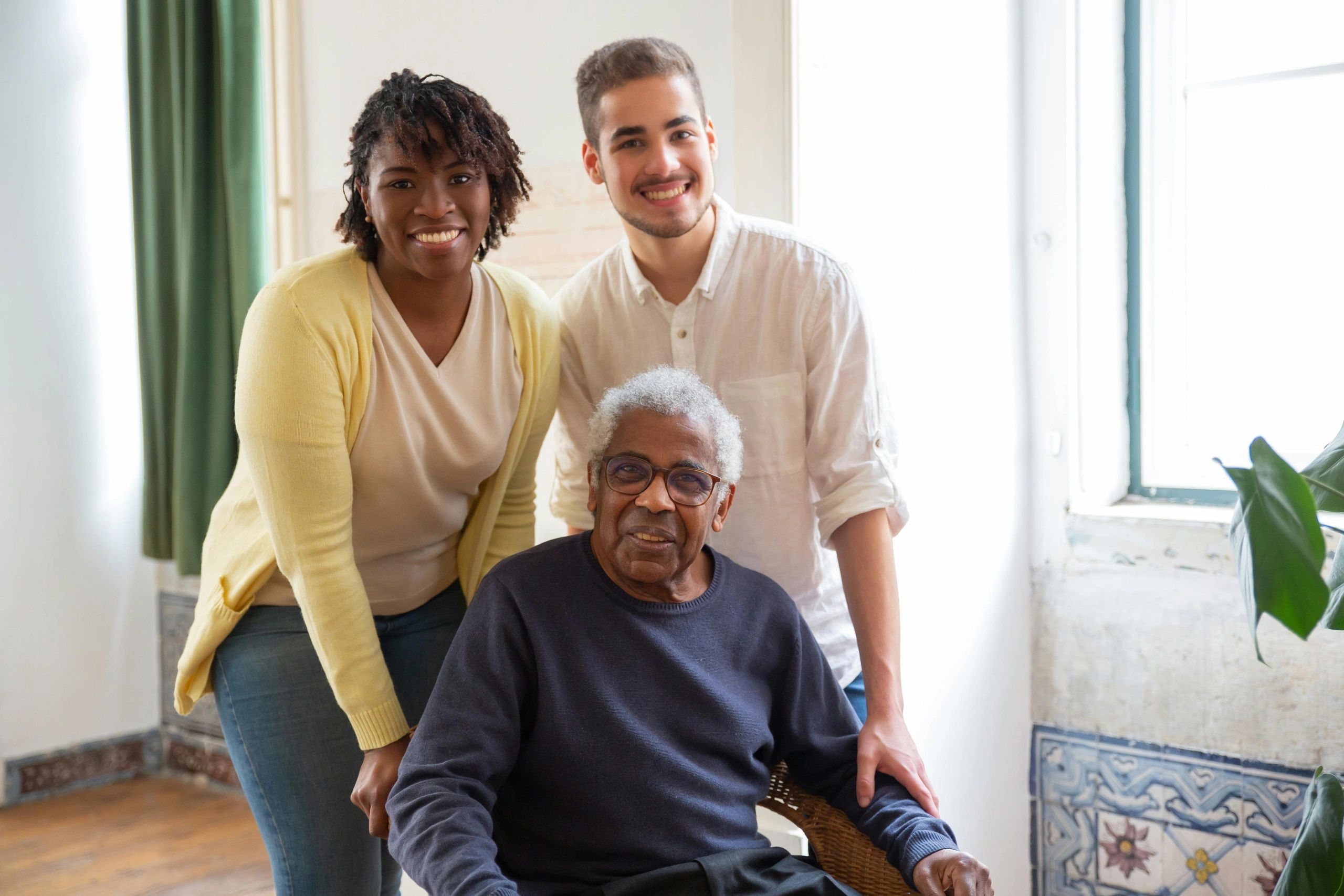 Three generations smiling together in a cozy room with natural light.