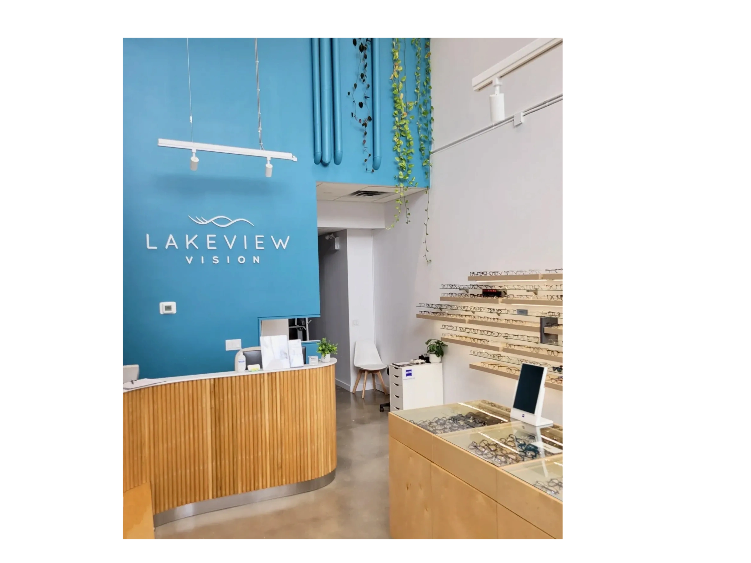 Modern eyeglasses store interior with blue accent wall and wooden displays.