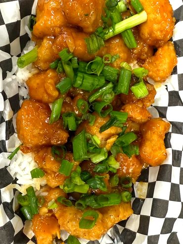 Up close image of the Orange Chicken. Featured is the Chicken, lightly breaded in an Orange sauce.