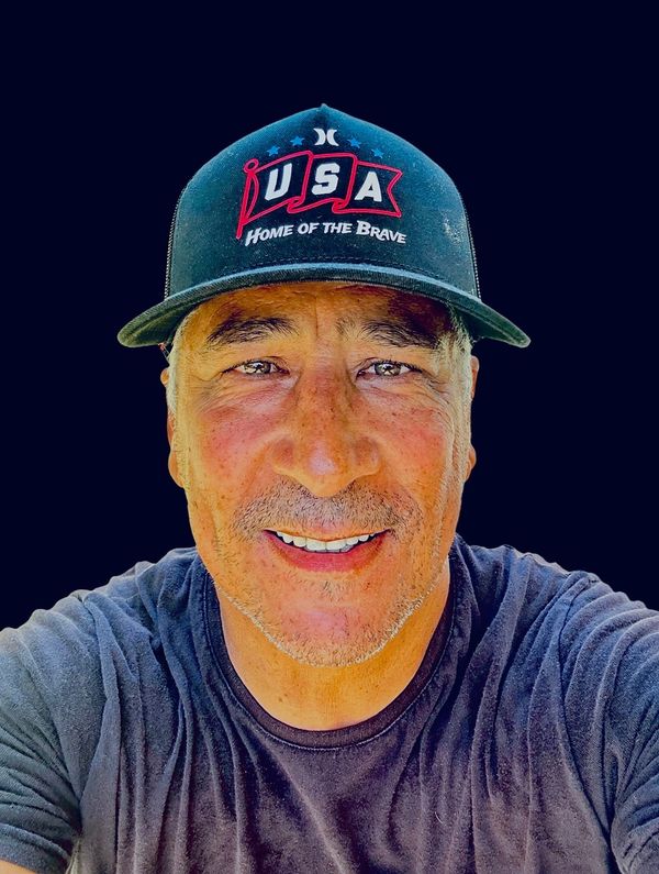 Man wearing a USA hat smiling at the camera.