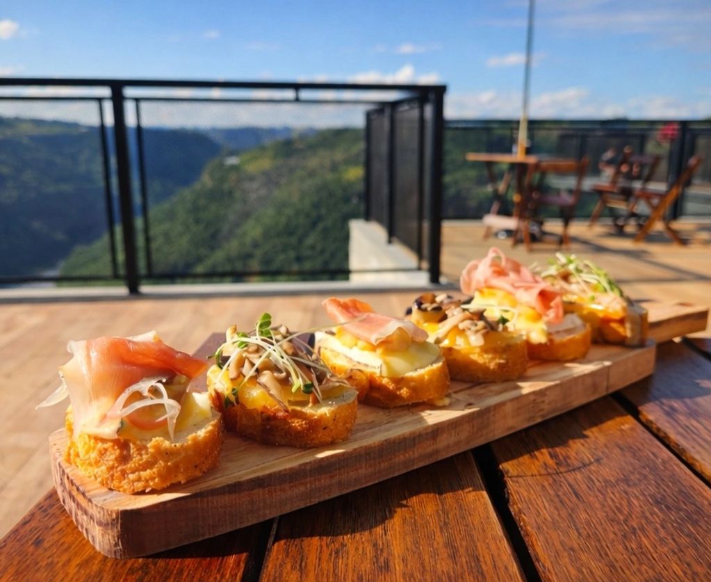 Canapés gourmet em uma tábua de madeira com paisagem ao fundo.