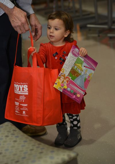 A little girl looking at her bag of toys at Toys For Our Troops