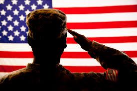 Soldier saluting American flag.