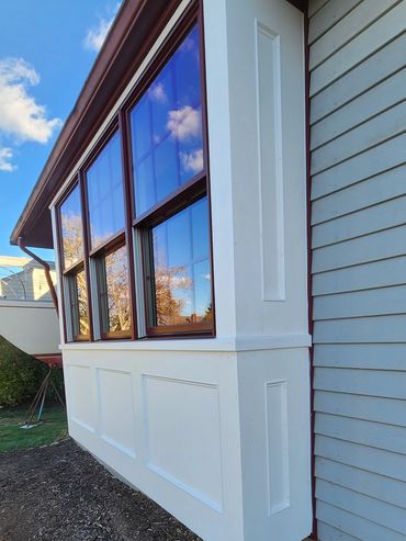 Side view of a house with large windows reflecting the sky.