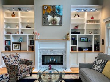 Cozy living room with fireplace and decorated shelves.