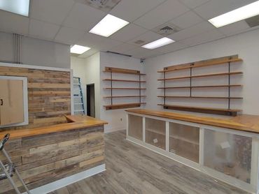 Empty retail space with wooden counters and shelves.