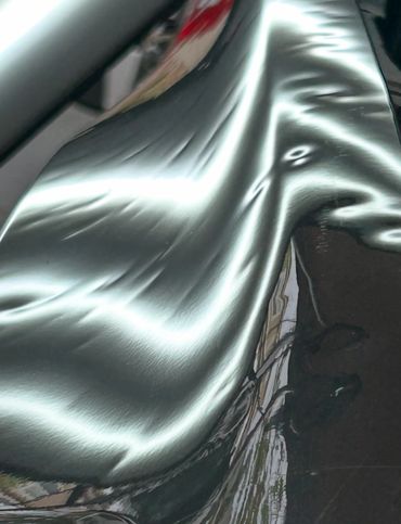 Close-up of a shiny, reflective black surface with light reflections.