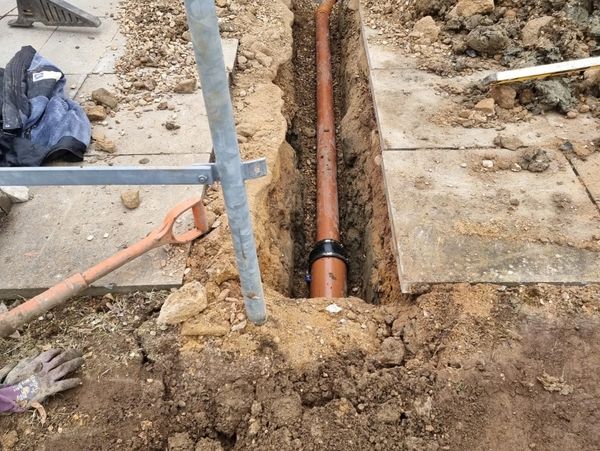 Pipe being placed under a pavement