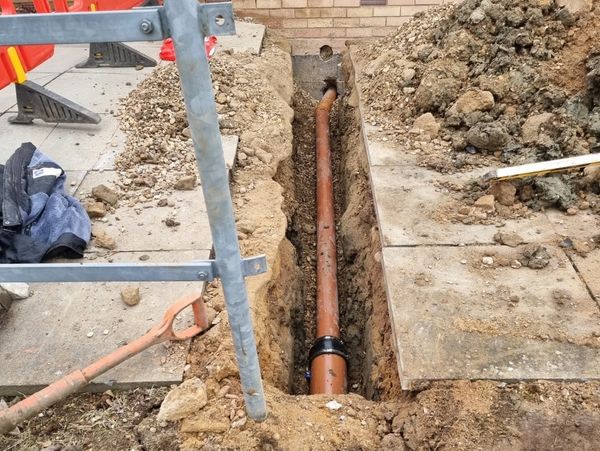 Pipe being placed under a pavement