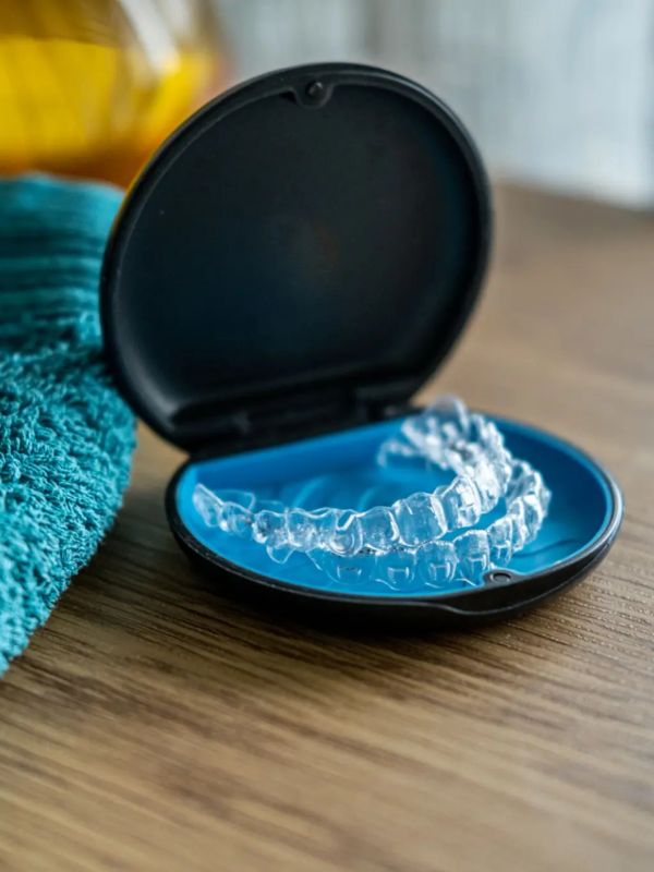Alineadores transparentes en estuche azul y negro.