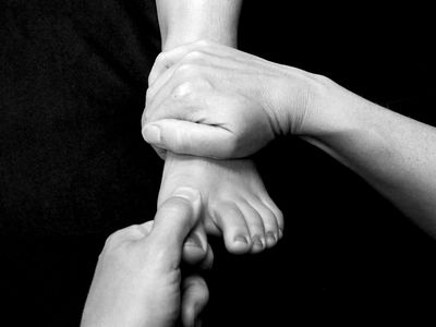 A chiropodist performs foot mobilization on a foot