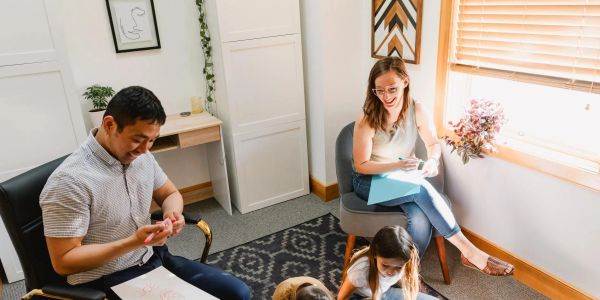Two adults and two children spending time together in a cozy room.